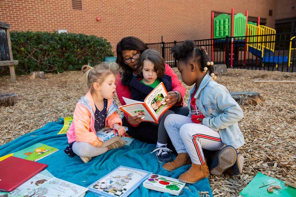 children reading a book together