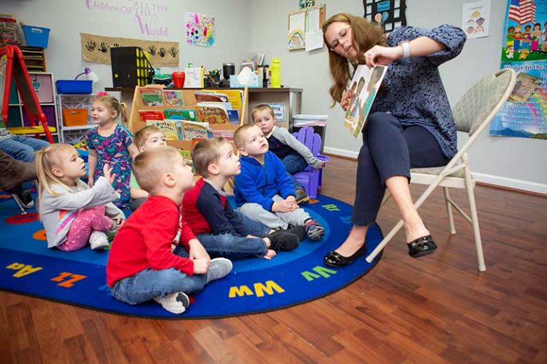 children listening to a story. Teacher reading story to group.